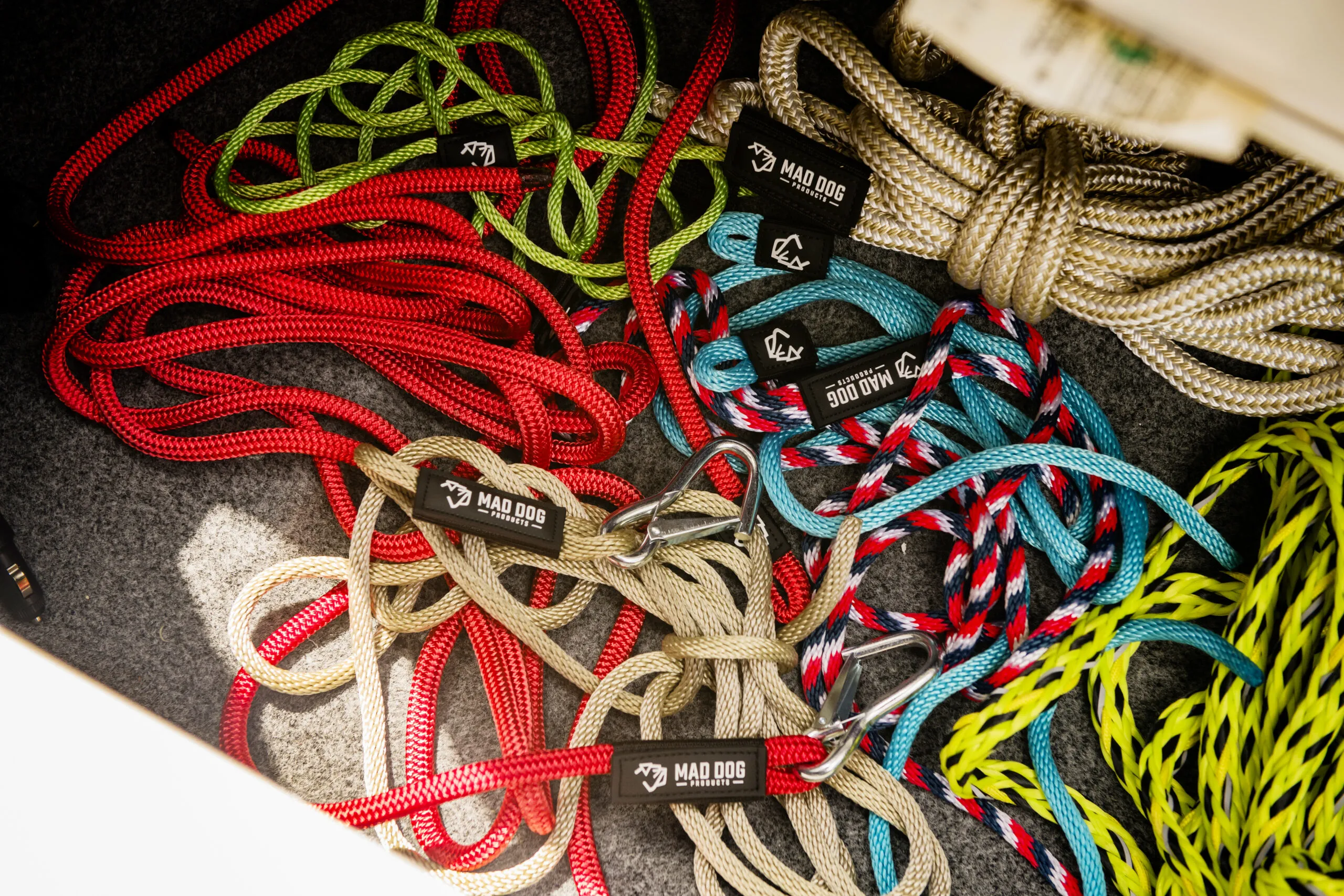 Assorted colorful braided ropes with carabiners and brand labels.